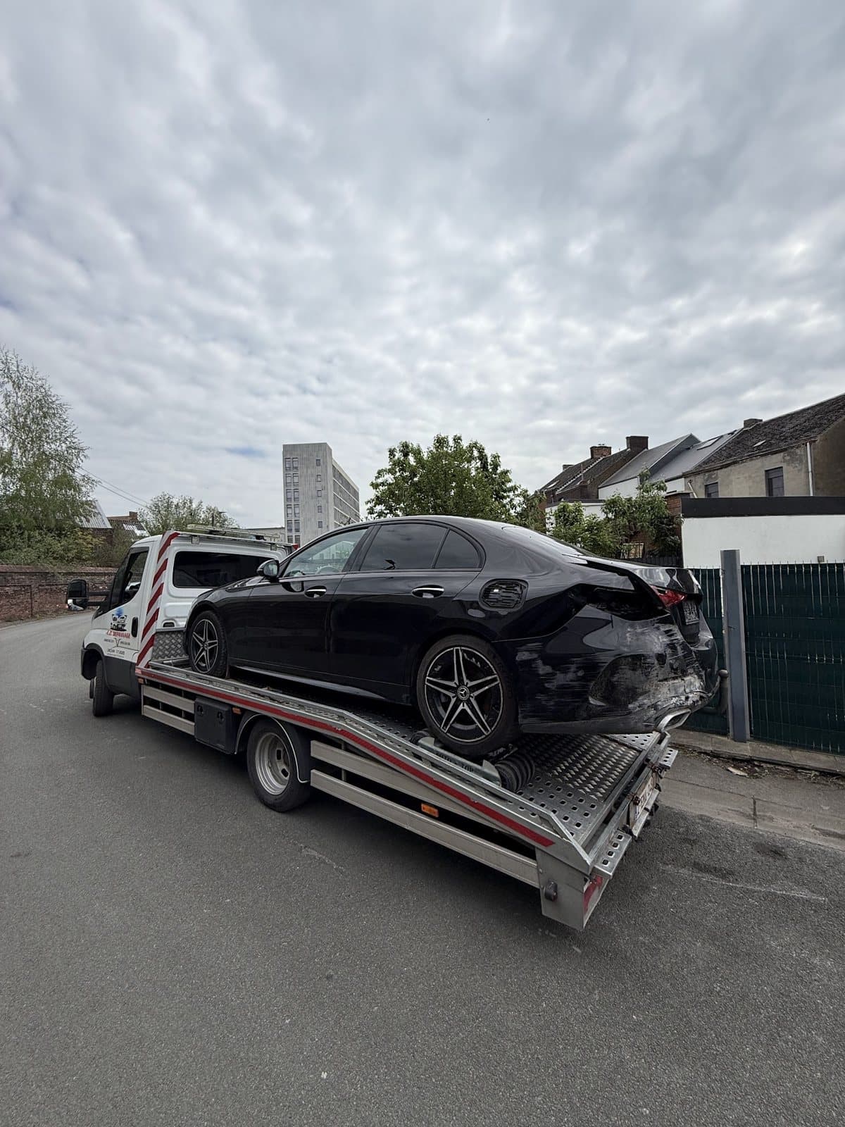 Une berline noire accidentée à l’arrière, sur le plateau